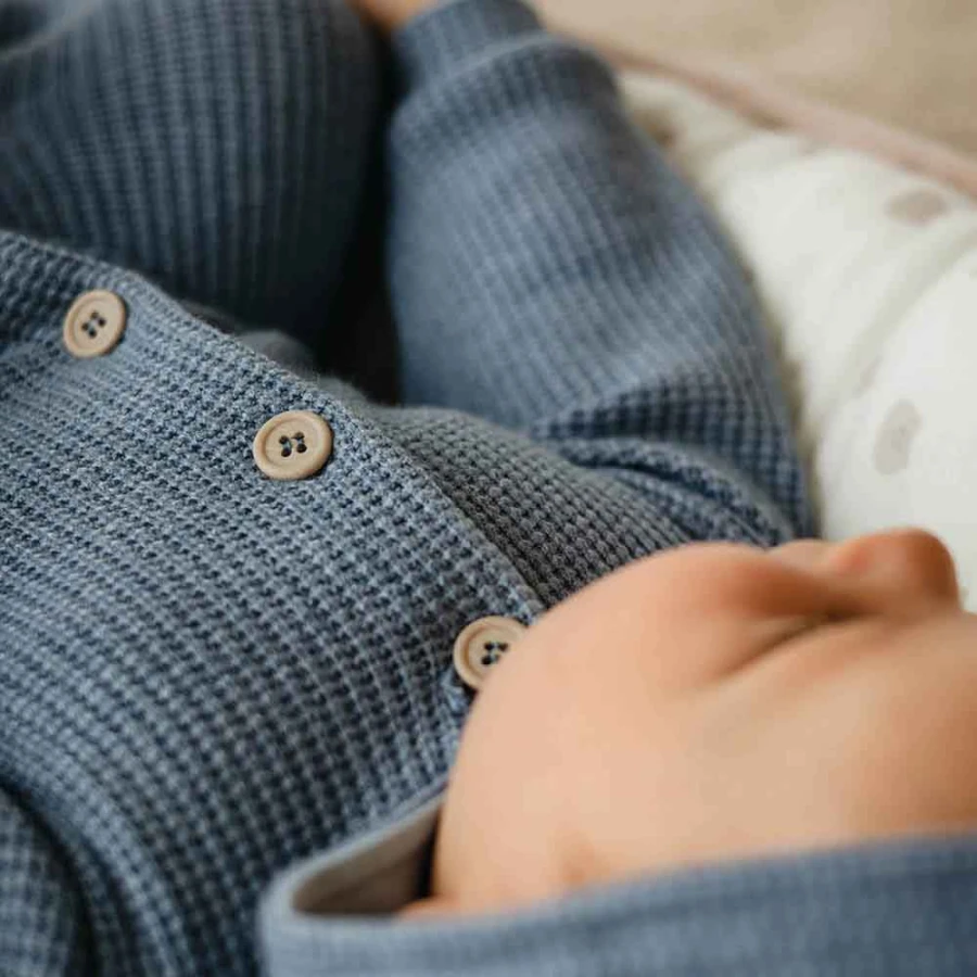 Blue knitted baby romper with hood